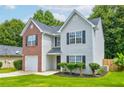 Charming two-story home features a well-manicured lawn, a brick facade, and complementary neutral siding at 7006 Mahonia Place, Stonecrest, GA 30038