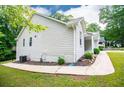 View of the home showcasing painted brick and vinyl siding plus a paved side entrance and lush lawn at 9691 Squirrel Wood Run, Douglasville, GA 30135
