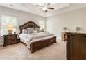 Comfortable bedroom featuring a tray ceiling, carpet flooring, and traditional furnishings at 1896 Grove Field Ln # 29, Marietta, GA 30064