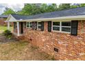 Side view of the beautiful brick house showing window shutters and green landscaping at 6213 Cherry Ln, Douglasville, GA 30134