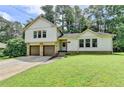 Inviting home with a two-car garage, lush green lawn, and a covered entrance area at 4398 Stonebridge Ct, Duluth, GA 30096