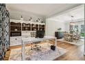 Well-lit office space with built-in shelving, desk, and hardwood floors, open to dining area at 1006 Amberton Ln, Powder Springs, GA 30127