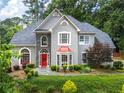 Beautiful home with well-maintained landscaping, a red door and stone accents for added charm at 570 Hunt River Way, Suwanee, GA 30024