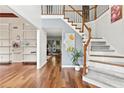 Inviting foyer featuring hardwood floors, a staircase, and open access to other rooms at 570 Hunt River Way, Suwanee, GA 30024