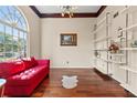 Bright living room with large windows, hardwood floors, stylish shelves, and a red sofa at 570 Hunt River Way, Suwanee, GA 30024
