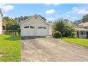 View of the front of the house featuring a two-car garage, driveway, and a lawn with healthy green grass at 2806 Vintage Wood Nw Way, Kennesaw, GA 30144