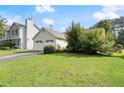Exterior view of the home showcasing its two-car garage, well-manicured lawn, and mature landscaping at 2806 Vintage Wood Nw Way, Kennesaw, GA 30144