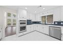 Bright kitchen features white cabinets, stainless steel appliances, sleek countertops, and eye-catching backsplash at 3009 Gant Quarters Dr, Marietta, GA 30068
