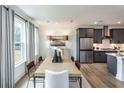 Elegant dining room with modern decor, featuring a large table, designer curtains, and a seamless transition to the kitchen at 586 Avondale Park Cir, Decatur, GA 30032
