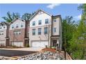A modern brick and painted brick townhome with attached garages and professionally landscaped yard at 586 Avondale Park Cir, Decatur, GA 30032
