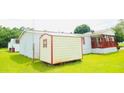 View of the manufactured home showing the lawn, and handy storage shed at 263 Gulfport Ct, Hampton, GA 30228