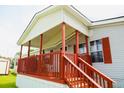 Inviting covered porch of a manufactured home, complete with wooden railing and steps at 263 Gulfport Ct, Hampton, GA 30228