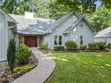 Home exterior with stone accents, light gray siding, well-maintained landscaping, and a walkway at 4212 Burns Heritage Ne Trl, Roswell, GA 30075