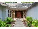 Inviting front entrance with stone surround and double wooden doors, surrounded by lush landscaping at 4212 Burns Heritage Ne Trl, Roswell, GA 30075