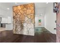 Open-concept living room with a unique stone wall feature, hardwood floors, and natural light at 4212 Burns Heritage Ne Trl, Roswell, GA 30075