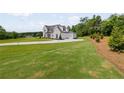 Expansive lawn leads to a distinguished two-story home featuring a three-car garage at 158 Palisade Dr, Rydal, GA 30171