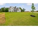 Well-manicured front lawn and a traditional two-story home under a bright sky at 158 Palisade Dr, Rydal, GA 30171