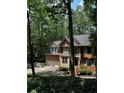 Charming two-story brick home nestled among lush greenery and trees, with an attached two-car garage at 1915 Habersham Trce, Cumming, GA 30041