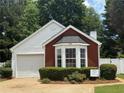 Charming exterior view of a home featuring manicured landscaping and a one-car garage at 214 Chelsea Ct, Woodstock, GA 30189
