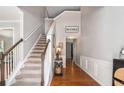 Inviting foyer featuring hardwood floors, a staircase with carpeted steps, and stylish decor at 3533 Aberdeen Way, Douglasville, GA 30135