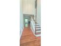 Inviting foyer with hardwood floors, staircase, and wainscoting detail that leads to living space at 2061 Fosco Dr, Duluth, GA 30097