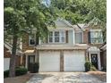 Charming townhouse featuring brick and siding, two-car garage, and well-maintained landscaping at 2061 Fosco Dr, Duluth, GA 30097