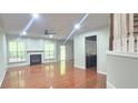 Bright living room featuring hardwood floors, a fireplace, ceiling fan, and access to the backyard at 2061 Fosco Dr, Duluth, GA 30097