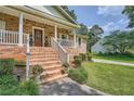 A welcoming brick home entrance featuring a covered porch with white railings and mature landscaping at 3812 Chattawood Dr, Duluth, GA 30096