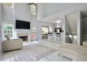 Bright, open-concept living room featuring high ceilings, a fireplace, and marble floors at 5996 Eagle Tiff Ln, Sugar Hill, GA 30518