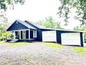 Charming blue home with white trim features a covered porch, detached garage, and well-maintained landscaping at 776 Green Dr, Canton, GA 30114