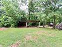 Covered storage area amidst lush greenery, perfect for storing wood and other outdoor items at 776 Green Dr, Canton, GA 30114