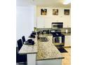 Open kitchen featuring granite countertops, modern stainless-steel appliances, and breakfast bar seating at 870 Mayson Turner Rd # 1207, Atlanta, GA 30314