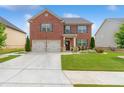 Charming two-story brick home with a well-manicured lawn, two-car garage, and inviting front entrance at 3303 Hawthorn Farm Blvd, Loganville, GA 30052
