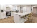 Bright, open kitchen with a central island, seating, and stylish white cabinets and appliances at 2089 Quilt Ct, Lithonia, GA 30058