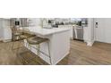 Modern kitchen island with bar seating, stainless steel appliances, and bright white cabinets at 2089 Quilt Ct, Lithonia, GA 30058