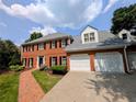 Two-story red brick home with a driveway and manicured lawn on a sunny day at 2903 Ashebrooke Ne Dr, Marietta, GA 30068