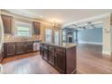 Open kitchen with island, stainless appliances, dark wood cabinets and hardwood floors at 1022 Nestling Dr, Lawrenceville, GA 30045