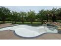 In-ground pool in need of replastering with a waterfall feature, surrounded by lush landscaping at 2609 Jacobs Crest Cv, Grayson, GA 30017