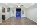 Bright living room featuring a blue brick fireplace, modern ceiling fan, and gray wood flooring at 225 Hardwood Dr, Covington, GA 30016