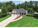 Charming two-story home boasts a brick and siding exterior, attached two-car garage, and a well-manicured front lawn at 232 Christian Cir, Carrollton, GA 30116