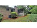 Brick home exterior with a screened porch, complemented by a well-maintained lawn and landscaping at 2600 Amberly Dr, Dunwoody, GA 30360