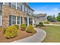 Close up of lovely home displaying a stone facade, covered front porch, and meticulously maintained shrubs at 2953 Balvenie Pl, Acworth, GA 30101
