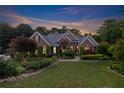 Charming brick home with manicured lawn, elegant landscaping and soft evening light at 1005 Cromwell Cv, Snellville, GA 30078