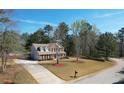 An aerial view displays a home with a long driveway, set back on a large lot with mature trees at 151 River Park Cir, Mcdonough, GA 30252