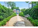 Landscaped backyard featuring a stone pathway, bench, and manicured hedges, creating a serene outdoor space at 67 Delmont Ne Dr, Atlanta, GA 30305