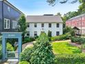 Attractive white house with lush landscaping and a welcoming neighborhood entrance gate at 67 Delmont Ne Dr, Atlanta, GA 30305