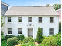 Classic two-story home with a white brick facade, complemented by lush green landscaping at 67 Delmont Ne Dr, Atlanta, GA 30305