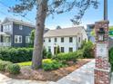 Beautiful two-story white house with manicured landscaping and a neighborhood entrance sign at 67 Delmont Ne Dr, Atlanta, GA 30305