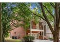 Brick house exterior with mature trees, garage, and a balcony at 2005 Eagle Rdg, Roswell, GA 30076