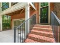 Inviting brick home entrance with steps, black door, and attached garage at 2005 Eagle Rdg, Roswell, GA 30076